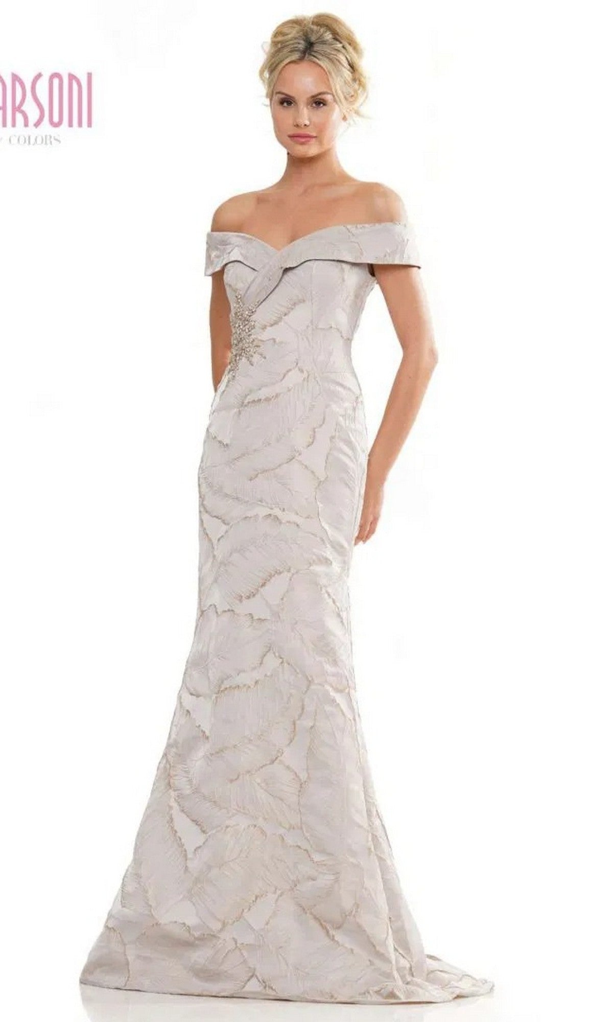 A woman faces forward in the Marsoni MV1266 long formal dress—a floor-length, fitted taupe gown with off-the-shoulder neckline, mermaid silhouette, and textured leaf-like pattern.